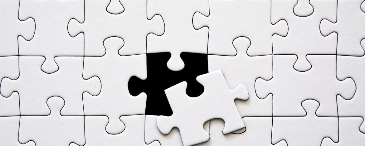 Ein weißes Puzzle bei dem mittig ein Teil herausgerutscht ist